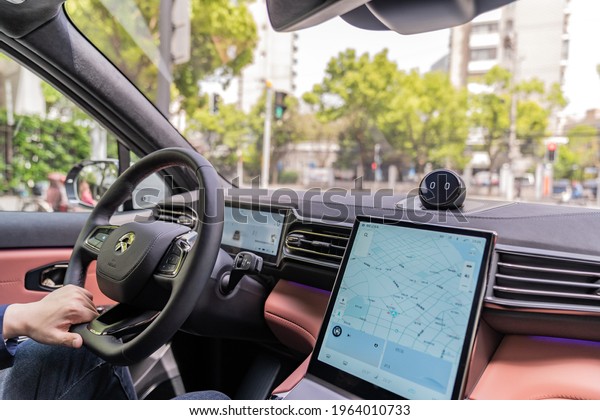 Shanghai, China. April 24, 2021. Editorial Use Only.\
Logo Nio on the Steering Wheel of Interior Electric Car. Driver is\
Driving Vehicle. 