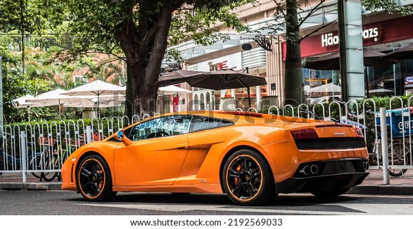 Shanghai, China- August 16,2022: An\
orange Lamborghini LP550-2 hypercar is parked in\
street