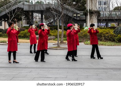 Shanghai, China - January 31, 2021: Elderly Woman With Traditional Clothes Practicing Chinese Fan Dance In A Public Park Near Yingao West Rd Metro Station, Baoshan District, Shanghai.