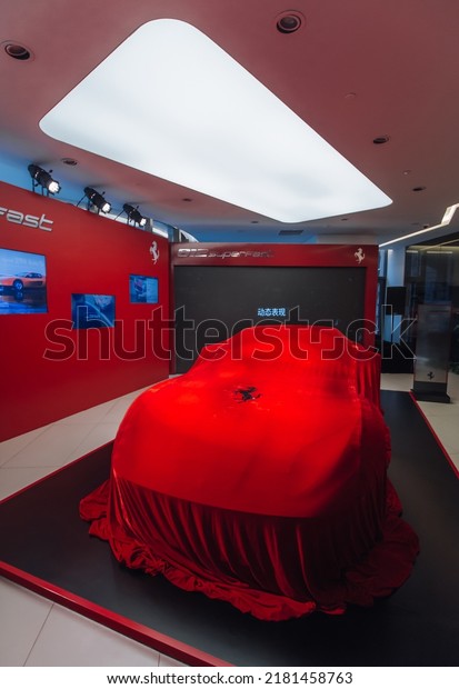 Shanghai, China- July 18,2022: a\
red Ferrari 812 Superfast hypercar is parked in showroom under\
cover