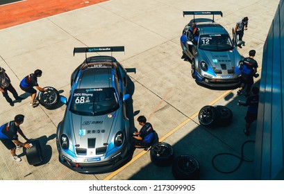 Shanghai, China- June 26,2022: A Group Of Mechanics Are Working On Two Silver Porsche 992 GT3 Cup Sportcars In Courtyard