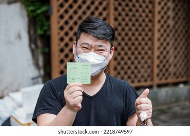 SHANGHAI, CHINA - May 25, 2022: A Chinese Man Showing A Health Card For A Negative Test And A Good Sign With Hand In Shanghai,China