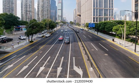 Shanghai, China - Oct. 23, 2019: High angle view of cars driving on city road with modern office buildings background.