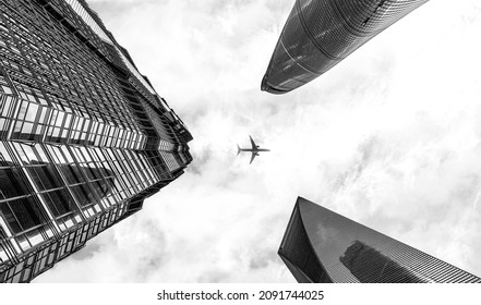 Shanghai, China - October 2nd 2021: Black And White Shot Of Plane Flying Over Modern Skyscrapers Of Shanghai