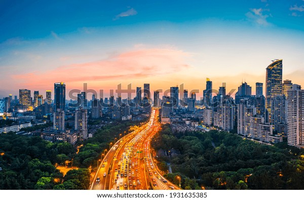 Shanghai\
skyline and buildings with highway at\
sunset.