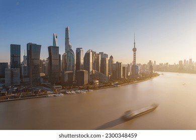 shanghai skyline in the day, showing the Huangpu river with passing cargo ships, financial district and cloudy sky background - Powered by Shutterstock