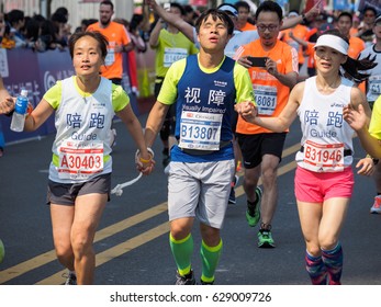 SHANGHAI,CHINA - April 23, 2017: Visually Impaired Marathon Runner And His Guide Running On City Road At 2017 Shanghai International Half Marathon.