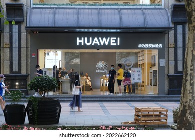 Shanghai.China-August 2021: Facade Of HUAWEI Electronic Store With Staff And Walking Chinese People In Face Mask