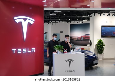 Shanghai.China-August 2021: Large Tesla Store Sign And Chinese Sales Staff In Face Mask. Tesla Is An American Electric Car Brand, Popular In China