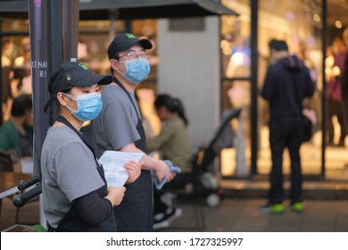 Shanghai/China-May 2020: Restaurant Staff Wearing Face Mask To Avoid Covid-19 Coronavirus, Standing Outside Restaurant. Blur Customers Background