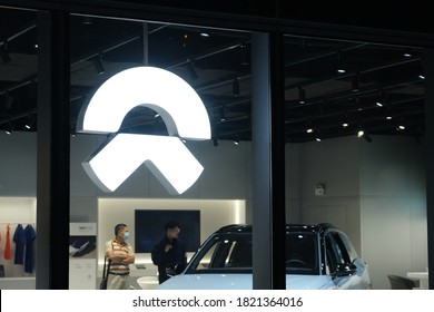 Shanghai,China-Sep.2020:close Up NIO Brand Logo In Store At Night. NIO Is A Chinese Electric Car Brand. 
 Customers Inside Buying Electric Car