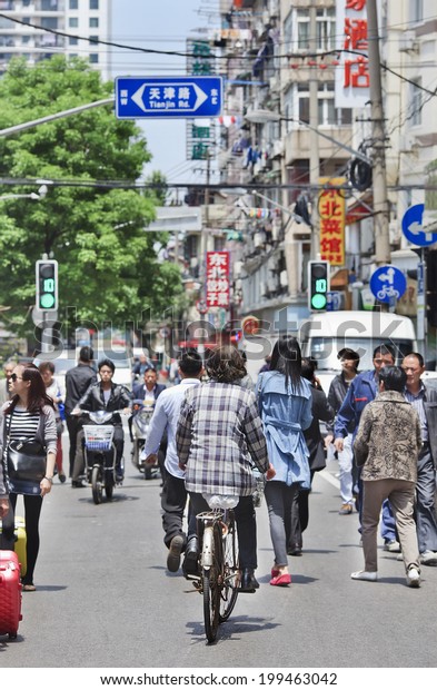 SHANGHAI-MAY 5, 2014. City dwellers on the street\
in a dense area. Urban densities average around 40,000 residents\
per square KM in core districts, 760 persons per hectare in Huangpu\
central area.