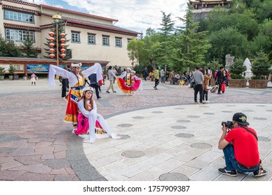 SHANGRILA,YUNNAN,CHINA-AUGUST 12,2019 : Many people in front of Guishan temple with giant buddhist tibetan prayer golden wheel in Dukezong ancient town