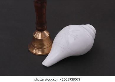 Shankh (Conch shell) and hand held brass bell (Ghanti) on black background