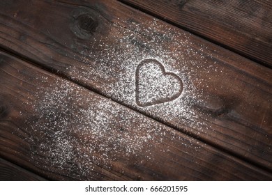 Shape Of A Heart With Powdered Sugar On Wooden Background