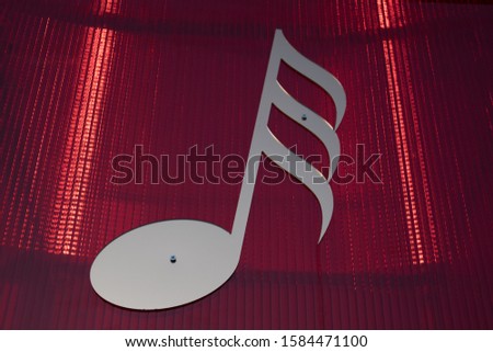 Shape of a thirty-second musical note, on a red light cube.
