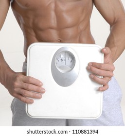 Shaped And Fitness Man Holding A Weight Scale.