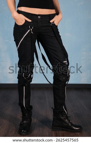Shapely legs, a young woman in tight pants and leather boots isolated on yellow background