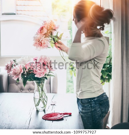 Similar – Woman with peonies on table in the living room