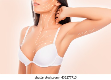 shapely young woman with perfect body with the drawing arrows wearing white bra, touching her neck