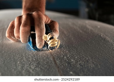 Shaping surfboard using a hand plane  - Powered by Shutterstock