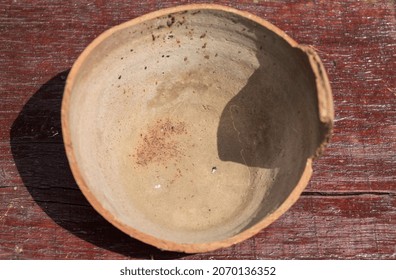 Shard Of Old Clay Jar, Pitcher Or Ceramic Pot. Broken Antique Clay Pot On A Wooden Table In The History Museum