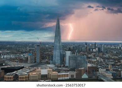 The Shard stands prominently in London's skyline as a bolt of lightning illuminates the stormy sky. The Thames River and diverse architecture are visible.