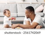 Shared Parental Leave. Young Black Father Playing With Little Baby At Home, Happy African American Man Spending Time With His Adorable Infant Child In Living Room, Enjoying Fatherhood, Copy Space