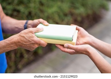 Sharing Books. Hand Closeup Giving Book Outdoors