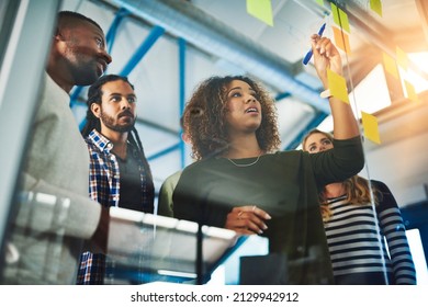 Sharing experience and expertise for an excellent brainstorming session. Shot of colleagues having a brainstorming session with sticky notes at work. - Powered by Shutterstock