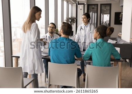 Sharing knowledge and insights. Collaborative multicultural team of diverse young doctors gather at clinic office to work on group research brainstorm ideas discuss diagnosis plan patients treatment
