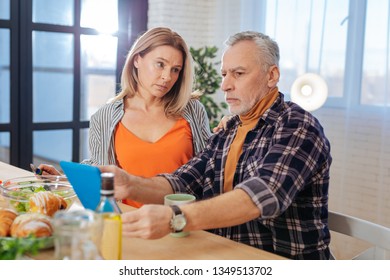 Sharing problems. Grey-haired bearded husband sharing his working problems with caring wife