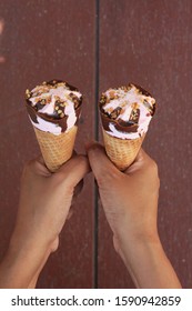 Sharing Two Ice Cream Cones.  Hands Holding Ice Cream Cones. Giving Is Caring. Lovely Strawberry And Chocolate Ice Cream Cone Image.