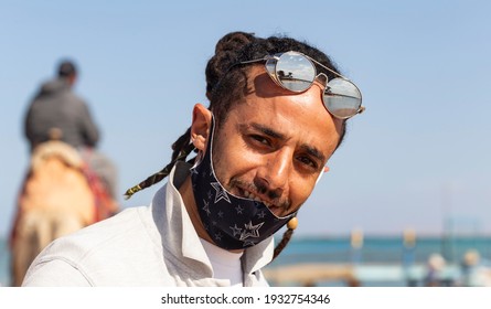 Sharm Ash Sheikh, Egypt - 01.16.2021. A Smiling, Positive Person. An Egyptian Travel Agent Wearing A Mask During The COVID 19 Pandemic. Red Sea Coast, Recreation Area.