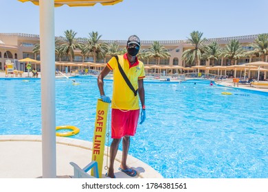 SHARM EL SHEIKH, EGYPT - JULY 27, 2020: Compliance With Quarantine On The Beaches Of Egypt. Hotel Worker In A Medical Mask And Gloves During Quarantine COVID-19. Hotels Are Ready To Meet Tourists