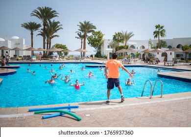 Sharm El Sheikh, Egypt - March 07, 2020: The animator entertains vacationers with exercises in the water. The trainer does an aqua gym class in the pool of an expensive hotel.