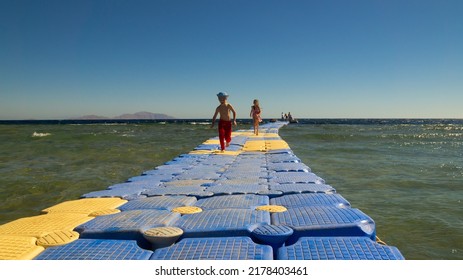 Sharm El Sheikh, South Sinai Egypt - 02.10.2022: Pontoon pier on the reef. Children on the pontoon pier on the beach.