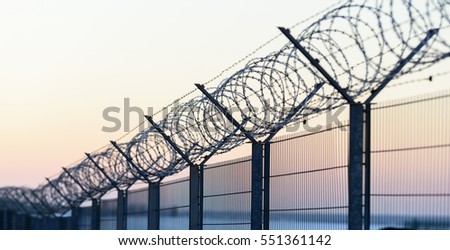 Sharp barbed wire on fence at cold winter