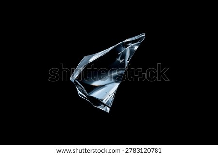 Sharp, clear glass fragment with subtle refractive light details, isolated on a solid black background for creative composite design.