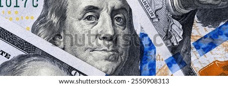 sharp, close-up view of benjamin franklins face from the one hundred dollar note.
