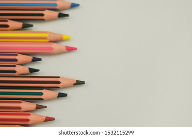 Sharp Colored Pencils Not Aligned Horizontally And Located On The Left Side On White Background