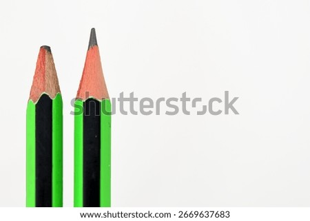 Sharp and Dull Pencils. A close-up of two green and black pencils against a plain white background, highlighting the contrast between a freshly sharpened and a dull one.