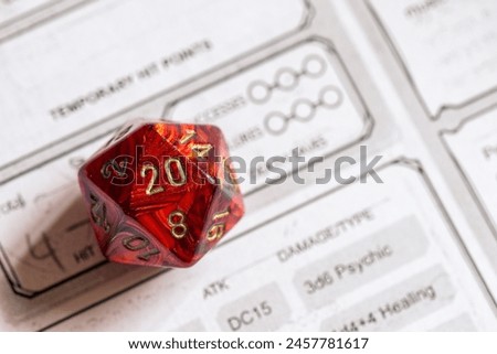 Sharp focus on a red D20 die resting on a detailed role-playing game character sheet, symbolizing strategy and chance in gaming