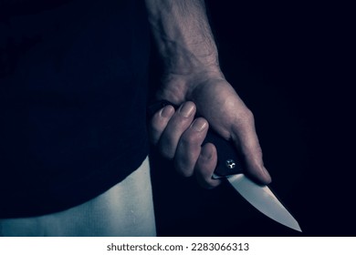 A sharp knife in the man's hand. The use of cold weapons. Knife attack . Armed raid..