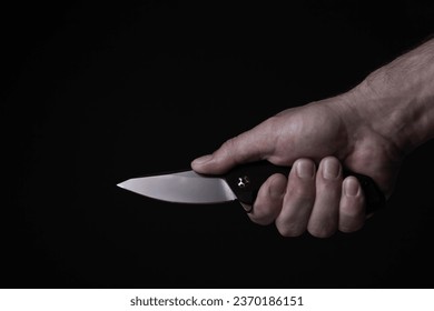 A sharp knife in the man's hand. The use of cold weapons. Knife attack . Armed raid.