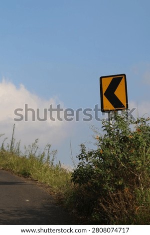 Sharp left turn traffic sign on the side of a mountain road.