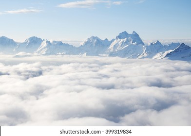 Sharp Mountain Peaks Sticking Out Of Clouds