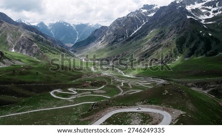Sharp mountain road zigzags in deep valley.