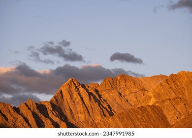 Sharp peaks of mountains in the light of the setting red sun