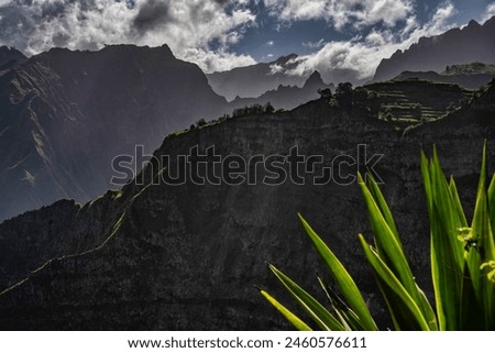 Sharp peaks of Santo Antão slice through a dramatic cloudscape, offering a stunning display of Cape Verde's rugged natural beauty, perfect for intrepid explorers and lovers of remote landscapes.